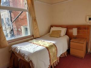拉格比钻石别墅酒店的一间小卧室,配有床和窗户