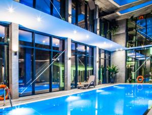 格里兹鲍Balteus Boutique Apartments的一座带窗户的建筑中的室内游泳池