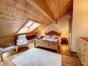 夏蒙尼-勃朗峰Bells Lodge的一间卧室设有一张床和木制天花板