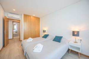 阿威罗Alameda 74 Luxury Apartment by Home Sweet Home Aveiro的酒店客房,配有两张带毛巾的床