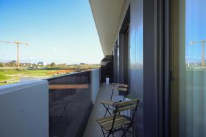阿威罗Alameda 74 Luxury Apartment by Home Sweet Home Aveiro的阳台配有椅子,享有建筑的景致。