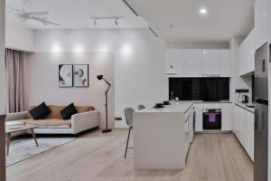吉隆坡H&N Luxury Suites KLCC的带沙发的白色客厅和厨房