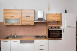 杜布罗夫尼克Apartment Tranquilo的厨房配有白色橱柜和白色冰箱。
