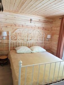 MedsėdžiųNamelis su ofuro vonia prie Plateliu ežero的卧室配有白色床和木制天花板