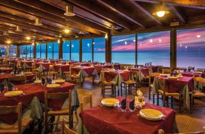 焦约萨马雷阿Baia Calavà Hotel e Residence的一间配备有桌椅的海景餐厅