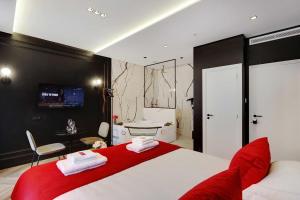 巴黎Couples Getaway Unit with Jacuzzi - City Center的一间带红色和白色床的卧室以及一间浴室。