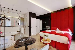 巴黎Couples Getaway Unit with Jacuzzi - City Center的一间带红色床的卧室和一间浴室