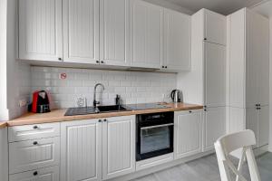 索波特Apartament na Monte Cassino w centrum Sopotu by Grand Apartments的白色的厨房配有白色橱柜和水槽