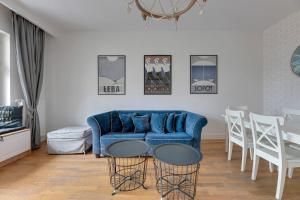 索波特Apartament na Monte Cassino w centrum Sopotu by Grand Apartments的客厅配有蓝色的沙发和桌子