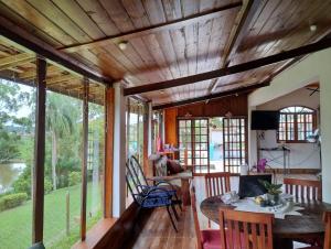 圣罗克Recanto Kamei-Piscina climatizada的客厅设有木制天花板和桌椅