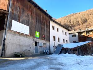 米施泰尔Privatzimmer Fasser in Müstair- Zentrale Lage的建筑的侧面有标志