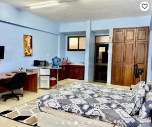 达累斯萨拉姆Queens Rentals - Studio Apartments - Village Walkway - Masaki - Dar es Salaam的一间卧室配有一张床、一张桌子和一台电脑