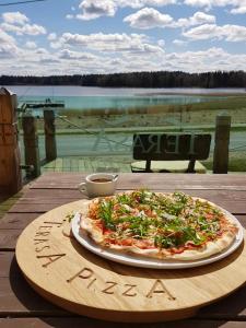 MedsėdžiųNamelis su ofuro vonia prie Plateliu ežero的木桌上摆着的比萨饼