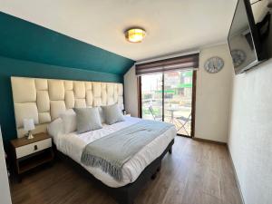 维纳德马Spazios Apart Hotel Reñaca的一间卧室设有一张蓝色墙壁的大床