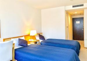 札幌HOTEL LiVEMAX Sapporo Ekimae的两张位于酒店客房的床,配有蓝色床单