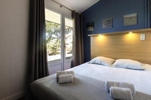卡布勒通Belambra Clubs Capbreton - Les Vignes的一间卧室设有一张大床和一个窗户。