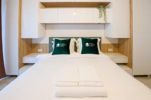 布加勒斯特Smart Concept Living Plaza的卧室配有带绿色枕头的大型白色床