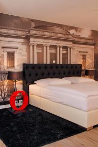 布伦瑞克豪斯楚汉萨同盟酒店的大楼前的卧室配有一张白色大床