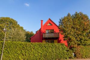 格赫伦-莱宾Ferienhaus Göhren-Lebbin的树 ⁇ 顶部带阳台的红色房子