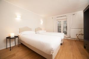 都灵Santantonio Suite, Porta Susa的白色卧室设有两张床,配有窗户