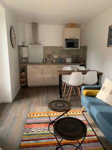 Bordères-sur-lʼÉchezAdorable Guest House « bienvenue chez vous ! »的一间带蓝色沙发的客厅和一间厨房