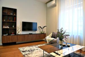 萨格勒布Nino Luxury Apartment的客厅配有电视、沙发和桌子