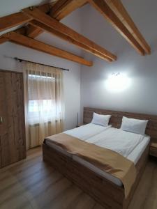 梅迪亚什Hanul Greweln的铺有木地板的客房设有一间带大床的卧室