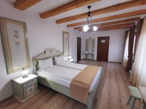 梅迪亚什Hanul Greweln的一间卧室设有一张大床,铺有木地板。