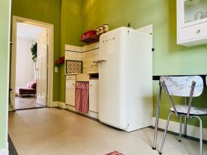 宾斯霍滕De Oude Pastorie的厨房设有绿色墙壁,配有白色冰箱