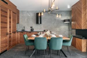 考斯赛力克Polana Resort by LoftAffair的一间带木桌和绿色椅子的用餐室