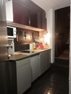 布勒伊-切尔维尼亚Cozy little studio in cervinia的厨房配有白色橱柜和台面