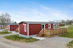 哈尔姆斯塔德First Camp Karlstorp-Halmstad的一座红色的小建筑,设有门廊和房屋