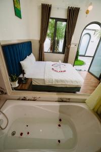 永隆VÂN TRANG GARDEN HOTEL 2的卧室配有床和浴缸