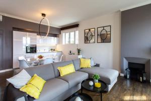 滨海自由城#24 Marie-Claire Suite Sea view/balcony/AC/5min port的客厅配有灰色的沙发和黄色的枕头。