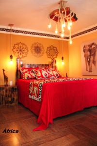 安谢塔Pousada No Meio do Mundo的一间卧室配有一张带红色毯子的床