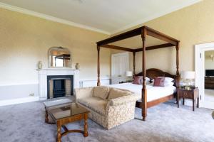 格伦罗西斯巴尔伯尼豪斯酒店的一间卧室设有一张天蓬床和一个壁炉