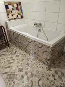 蓬格拉纳达蓝旅馆的带浴缸的浴室,铺有瓷砖地板
