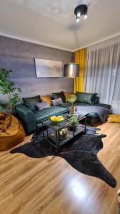 班斯科Apartmanica Double room apartment with balcony, St Ivan Rilski 4 star SPA Resort, Bansko的客厅配有绿色沙发和桌子
