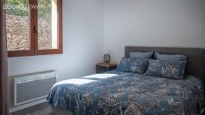 博尼法乔Villa Colombo的一间卧室配有一张带蓝色毯子的床和窗户。