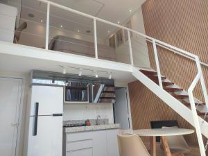 阿拉沙Ybira Loft的阁楼上的厨房设有螺旋楼梯