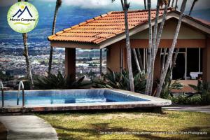 圣何塞Hotel Monte Campana Escazu的房屋前的游泳池