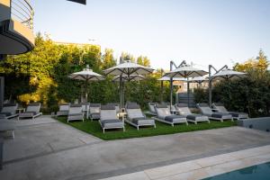 卡拉马塔Garden City Resort的草坪上的一组躺椅和遮阳伞