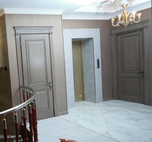 巴库West inn Hotel & Restaurant的走廊设有两扇门和吊灯