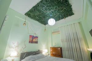 雅典Neoclassic modern apa Ath的一间卧室设有一张带绿色天花板的床。