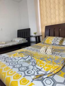 佛罗里达布兰卡Hospedaje Balcones de la Colina的一间卧室配有两张带黄色和蓝色毯子的床