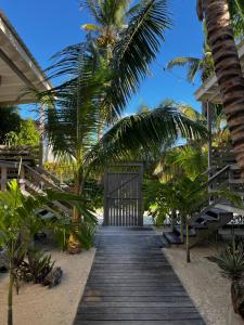 库尔克岛DreamCabanas的一条通往棕榈树海滩的木道