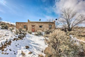 El PradoCasita Vacation Rental Near Taos with Patio!的一座带建筑物的雪覆盖的山丘上的房子