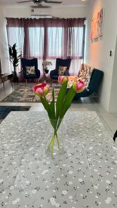 北赖D Naurah Meritus Guesthouse的客厅里带花的花瓶
