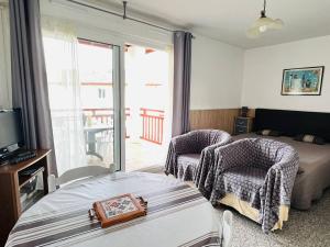 康博莱班Appartement Cambo-les-Bains, 1 pièce, 2 personnes - FR-1-495-16的一间卧室配有一张床、两把椅子和一个窗户