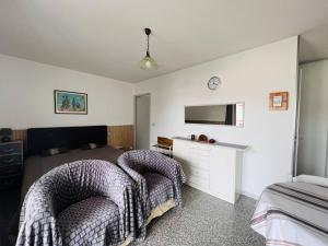 康博莱班Appartement Cambo-les-Bains, 1 pièce, 2 personnes - FR-1-495-16的一间卧室设有两张床,墙上配有电视。